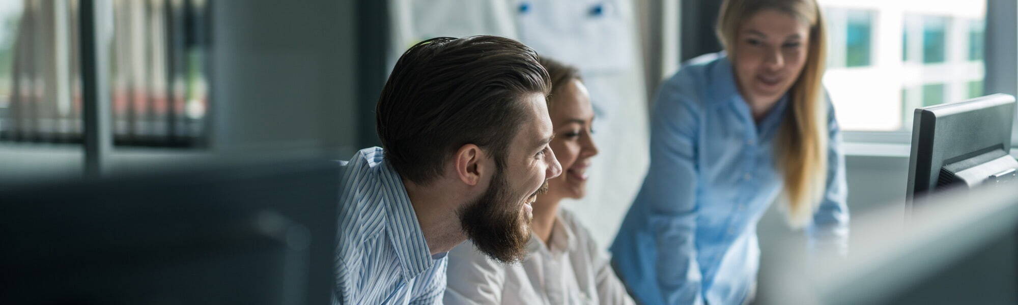 close up of 3 people grouped round a computer