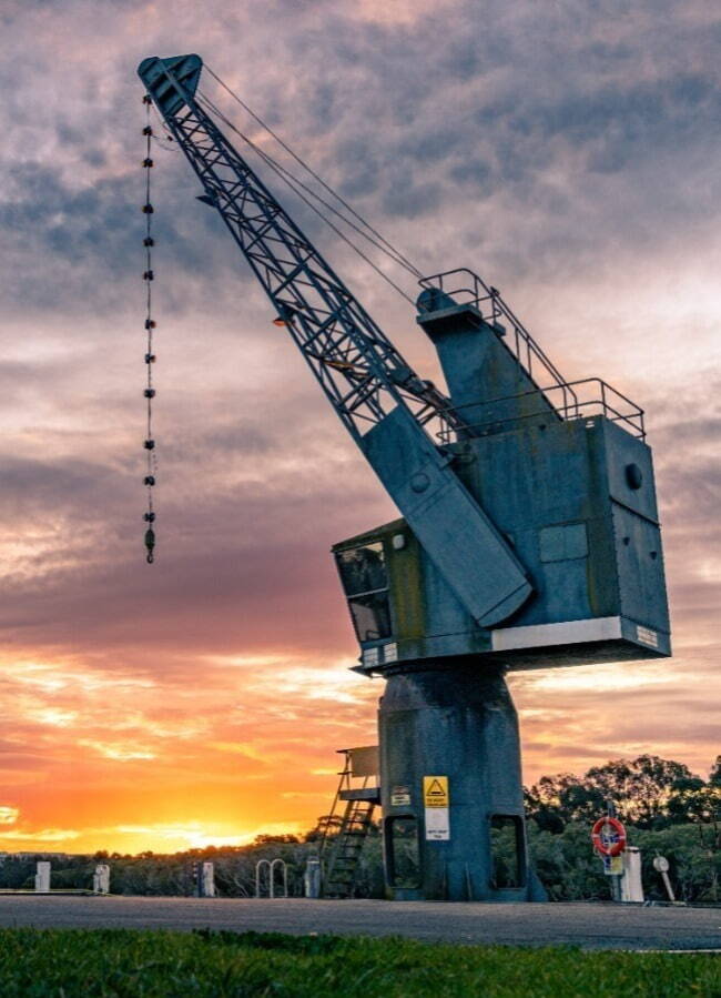 image of a large crane with a sunset background