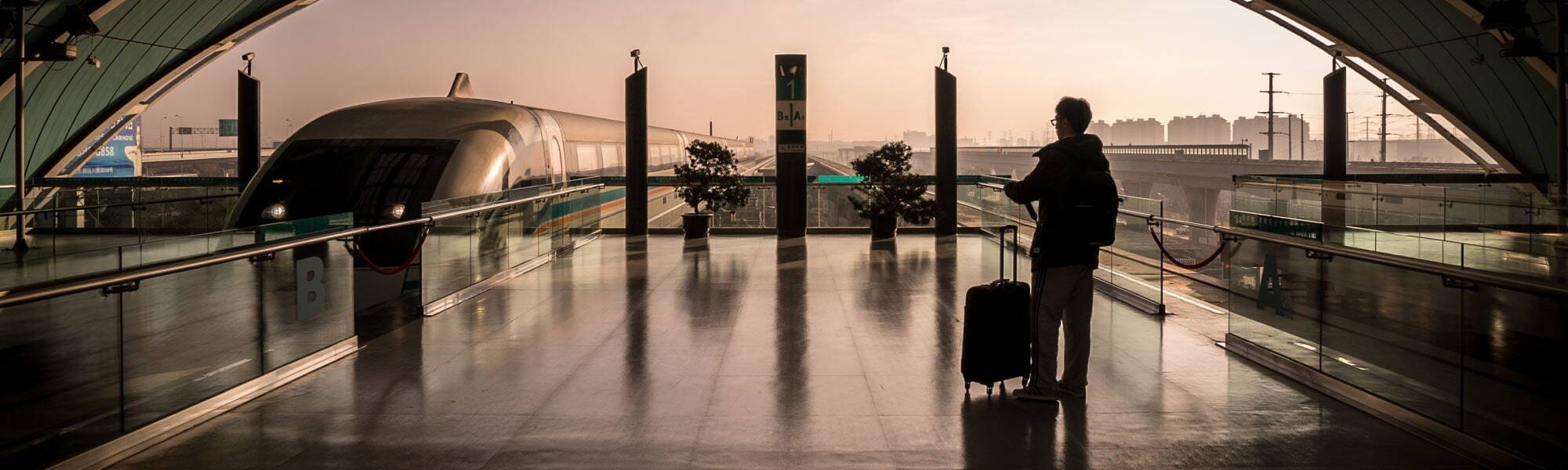 Silhouette of a man standing at a train station, train pulling in.