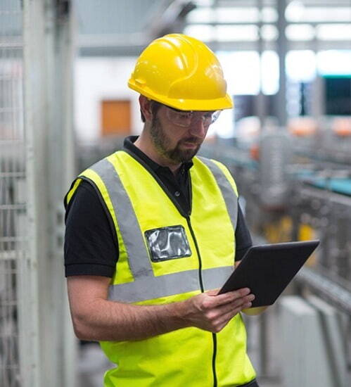 man wearing yellow safety vest and hard hat with a clipboard