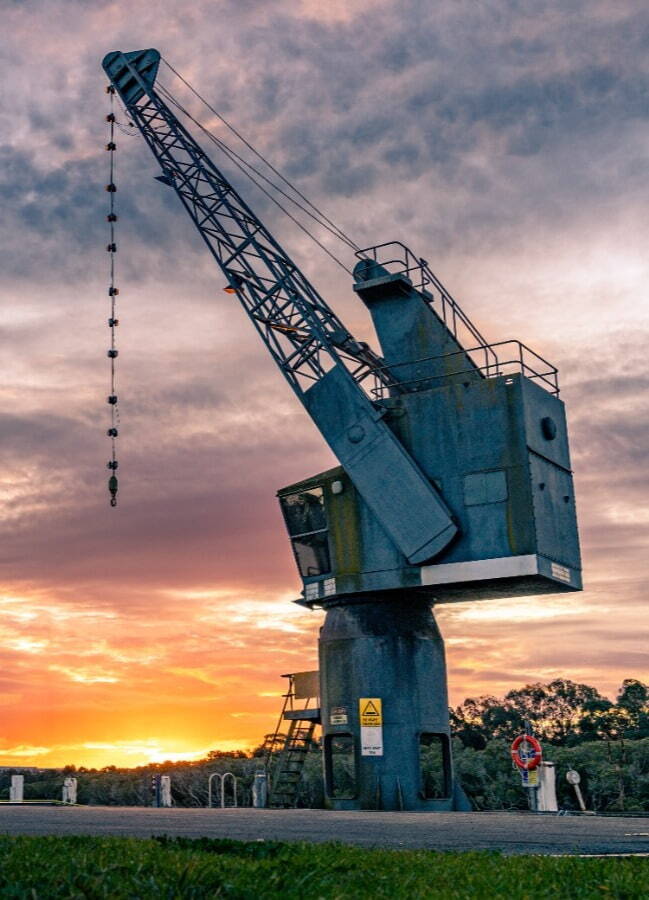 image of a large crane with a sunset background