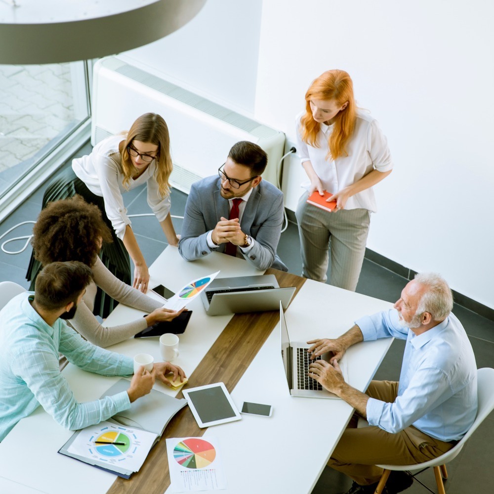 aerial view of a group of 6 people around a table in a meeting