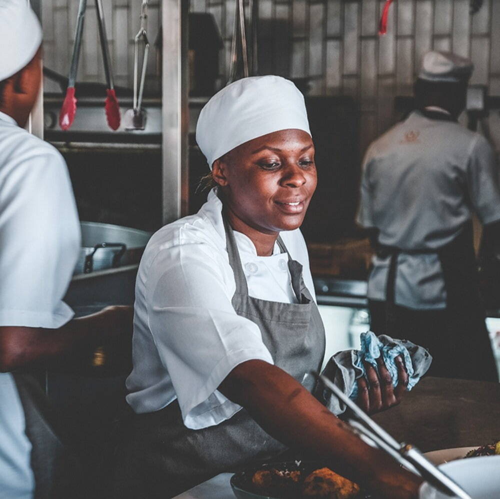 female chef wearing white hat, preparing food