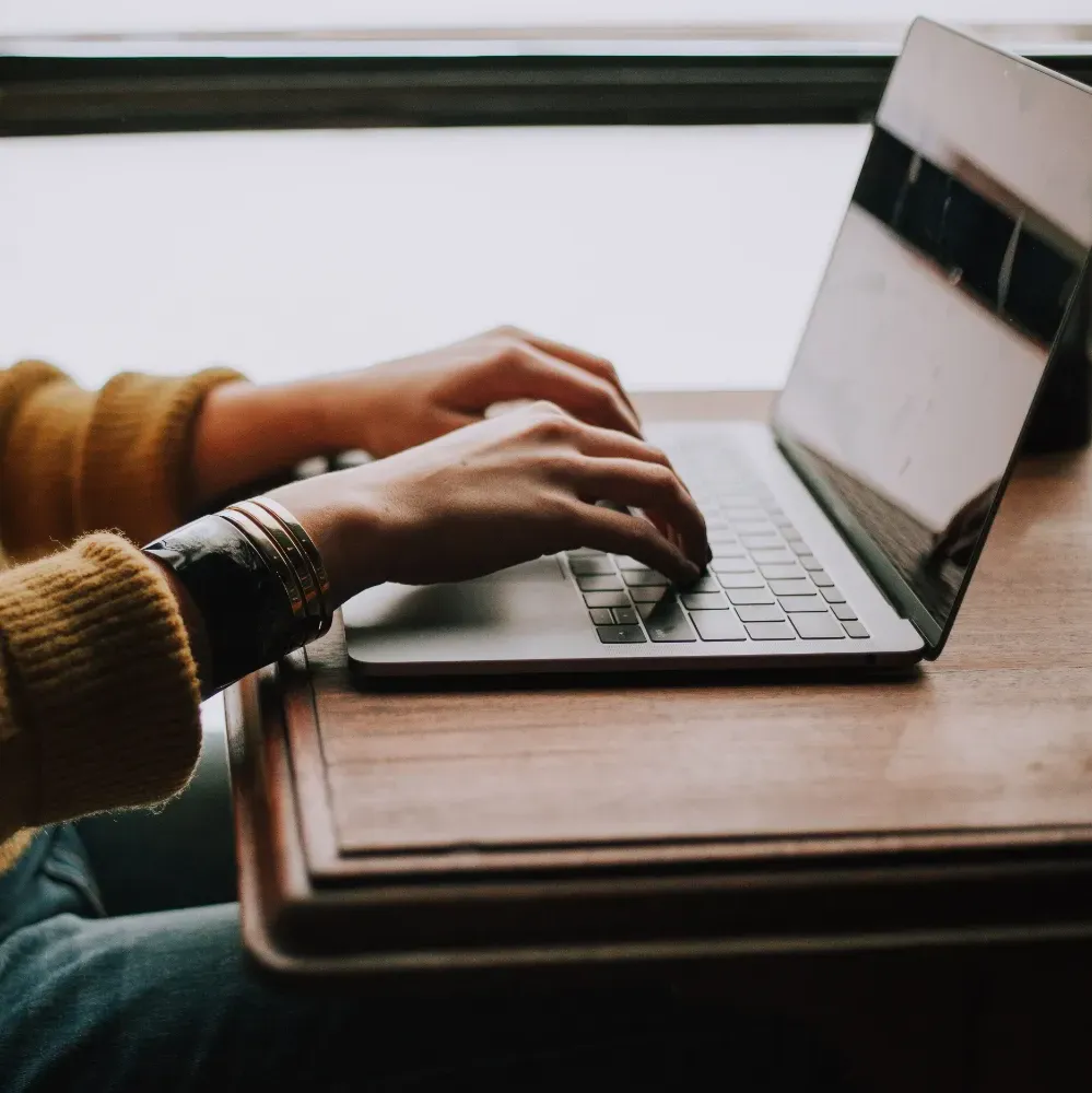 close up of someone's hands typing on a laptop