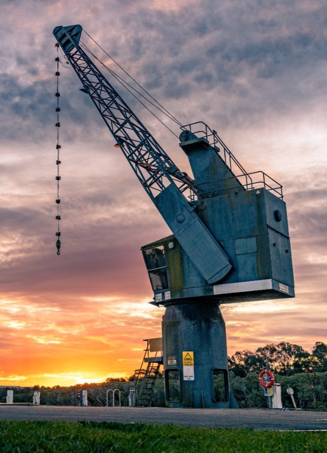 image of a large crane with a sunset background