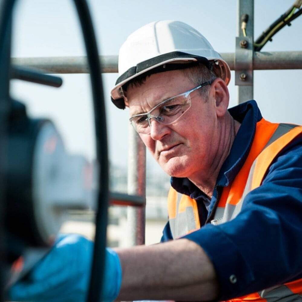 man and woman engineers working with hi-vis and hardhats